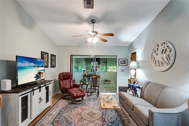 living room with ceiling fan, wood-type flooring, and a textured ceiling