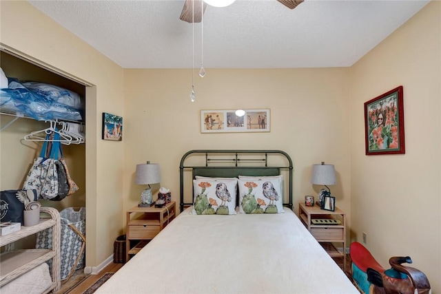 bedroom with wood-type flooring, a textured ceiling, and ceiling fan