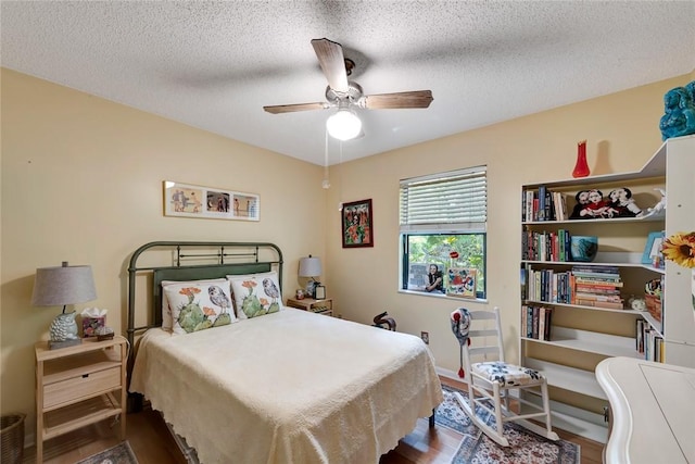 bedroom featuring hardwood / wood-style floors, a textured ceiling, and ceiling fan