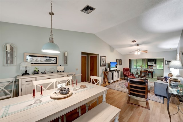 dining area featuring vaulted ceiling, ceiling fan, and light wood-type flooring