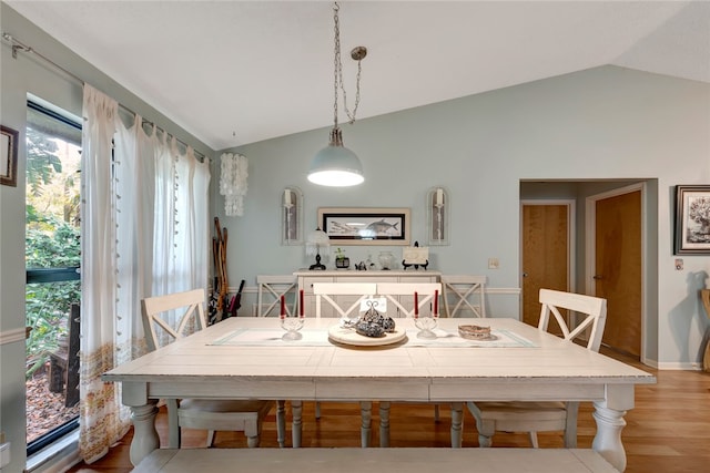 dining room featuring lofted ceiling and light hardwood / wood-style flooring