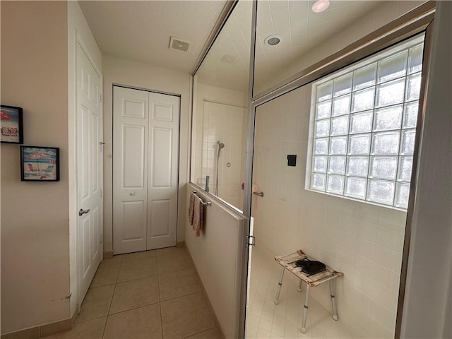 hallway featuring light tile patterned floors and visible vents