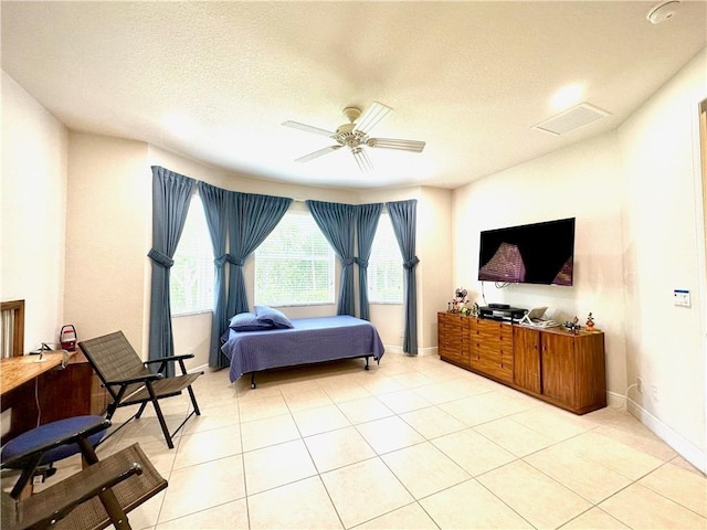 bedroom with light tile patterned flooring, baseboards, a textured ceiling, and ceiling fan