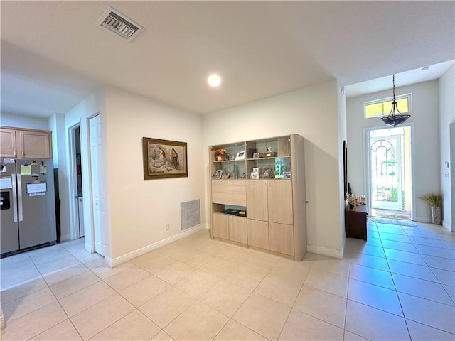 interior space with light tile patterned floors, visible vents, and baseboards