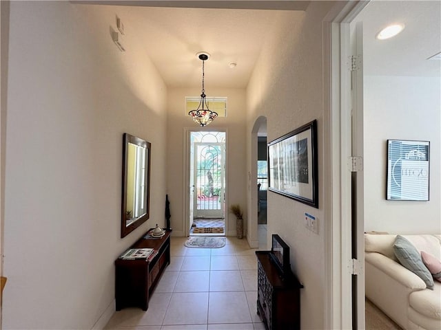 doorway with light tile patterned floors and arched walkways