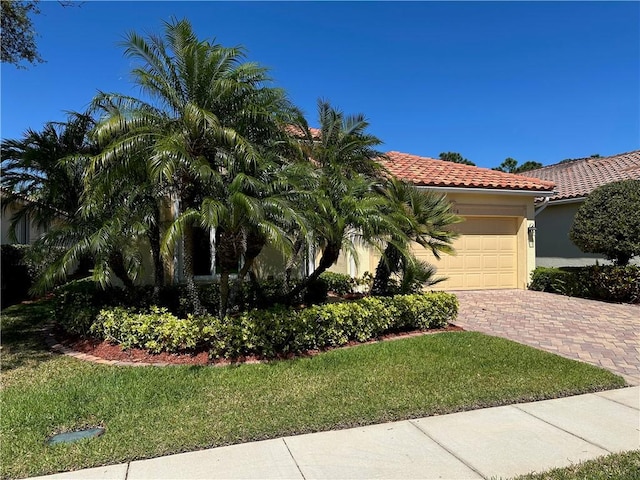 view of front of house with stucco siding, a front lawn, decorative driveway, a garage, and a tiled roof