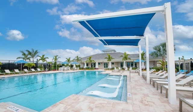 community pool with fence and a patio area