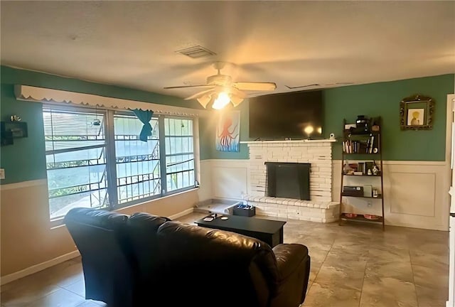 1606 34th Ave, Vero Beach, FL 32960 - living area featuring a ceiling fan, healthy amount of natural light, a wainscoted wall, and a fireplace