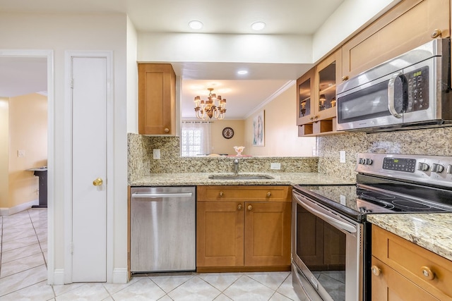 kitchen featuring light stone counters, sink, ornamental molding, and stainless steel appliances