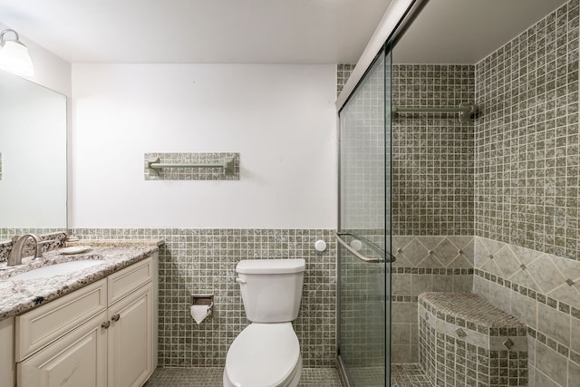 bathroom featuring vanity, toilet, tile walls, and walk in shower