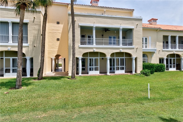 back of house featuring a yard, ceiling fan, and a balcony