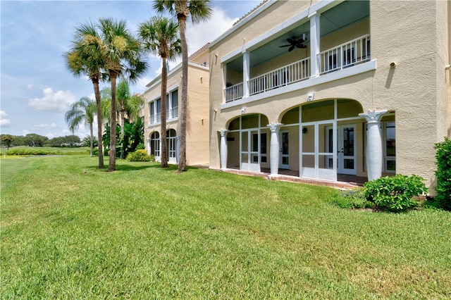 back of house with a yard, ceiling fan, and a balcony