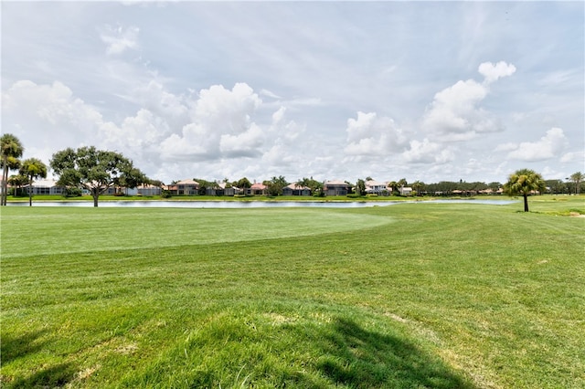 surrounding community featuring a water view and a lawn