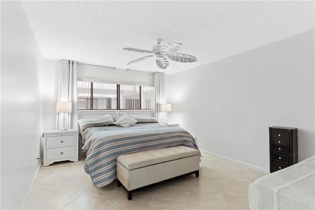 tiled bedroom with ceiling fan and a textured ceiling