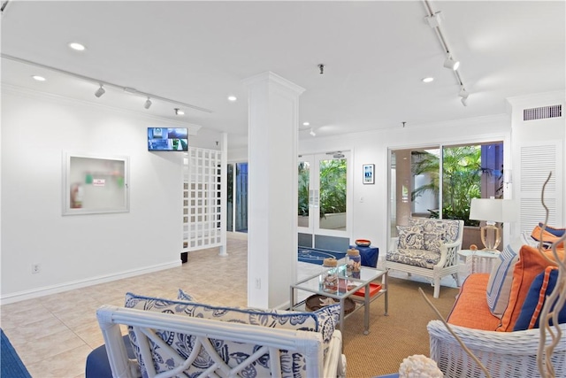 tiled living room featuring ornate columns, rail lighting, and ornamental molding