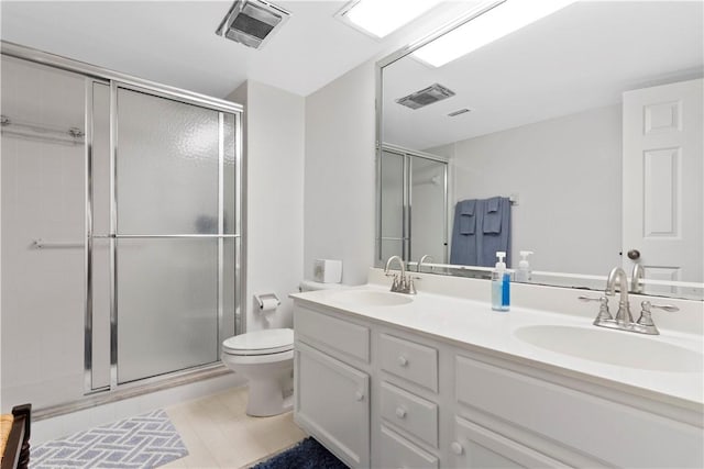 bathroom with vanity, toilet, and a shower with shower door