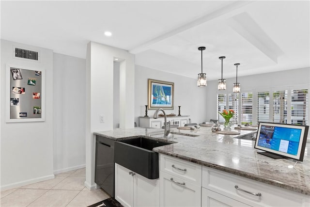 kitchen with white cabinetry, hanging light fixtures, light tile patterned flooring, and light stone countertops