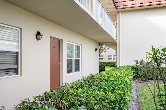 view of exterior entry with a balcony