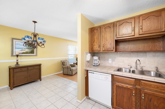 kitchen with tile countertops, dishwasher, a chandelier, tasteful backsplash, and decorative light fixtures