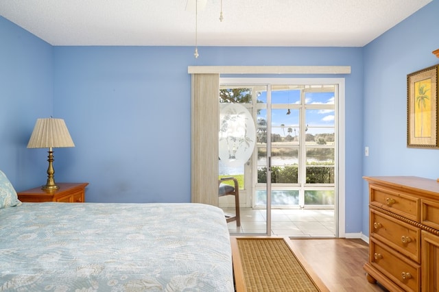 bedroom with light hardwood / wood-style flooring and a textured ceiling