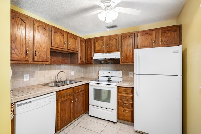 kitchen featuring light tile patterned floors, sink, ceiling fan, backsplash, and white appliances