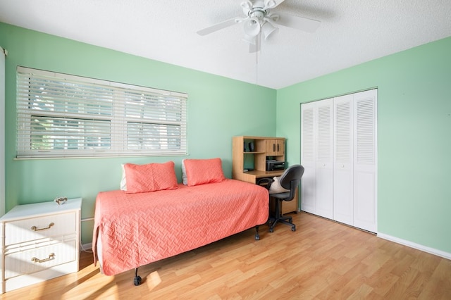 bedroom with ceiling fan, a textured ceiling, a closet, and light wood-type flooring