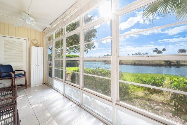 sunroom / solarium featuring a water view, a healthy amount of sunlight, and ceiling fan