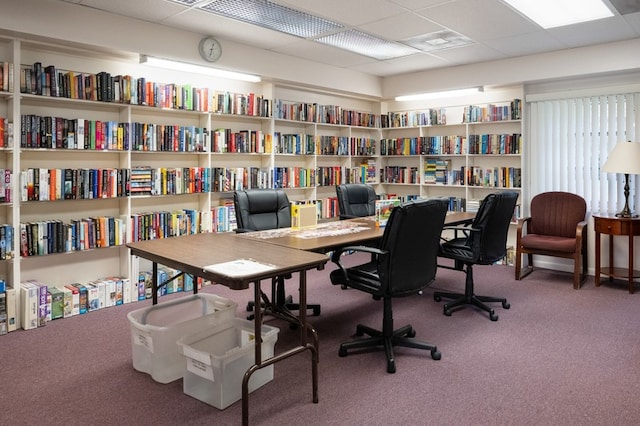 office space with a paneled ceiling and carpet