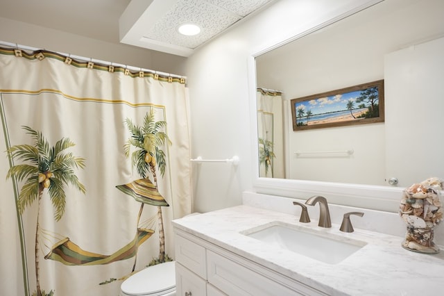 bathroom with toilet, vanity, and curtained shower