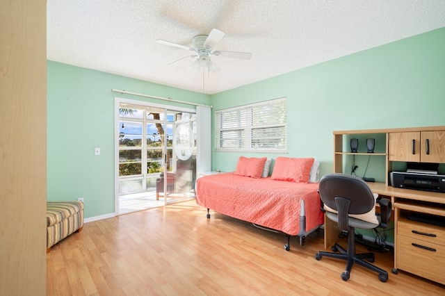 bedroom featuring light wood-type flooring, a textured ceiling, ceiling fan, and access to exterior