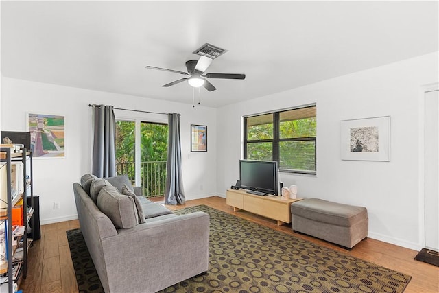 living area with dark wood-style floors, visible vents, ceiling fan, and baseboards