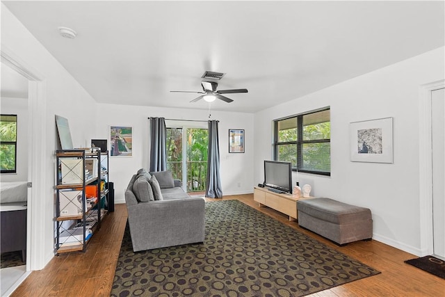 living area featuring plenty of natural light, visible vents, and dark wood finished floors