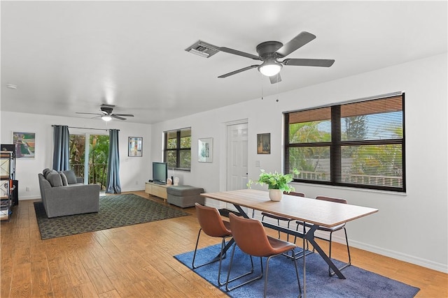 dining room with light wood-style flooring, visible vents, baseboards, and ceiling fan