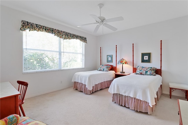 bedroom featuring multiple windows, ceiling fan, and light colored carpet