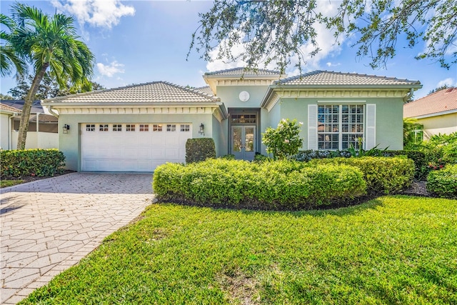 mediterranean / spanish-style home with a garage and a front lawn