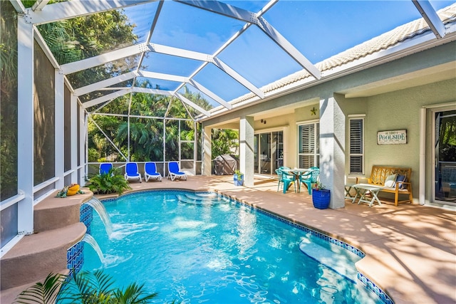 view of pool with a lanai, a patio area, and pool water feature