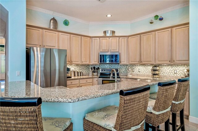 889 Island Club Sq, Vero Beach, FL 32963 - kitchen with stainless steel appliances, a kitchen breakfast bar, light stone countertops, decorative backsplash, and ornamental molding