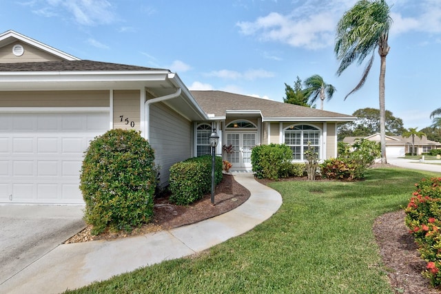 single story home featuring a garage and a front yard