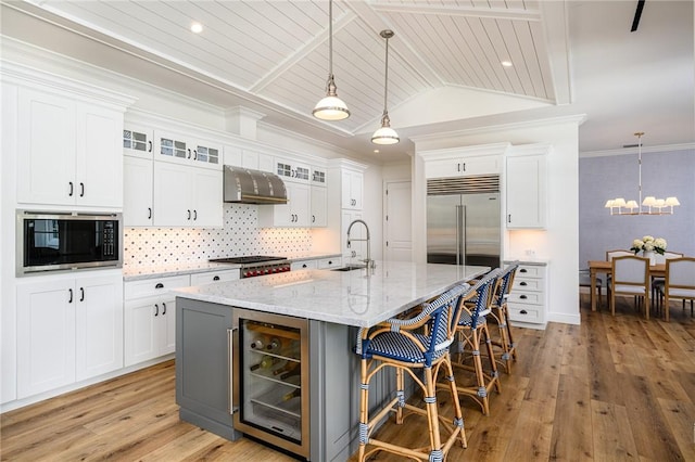 40 White Orchid Way, Vero Beach, FL 32963 - kitchen with beverage cooler, built in appliances, a sink, backsplash, and a chandelier