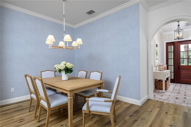 40 White Orchid Way, Vero Beach, FL 32963 - dining space featuring a chandelier, wood finished floors, ornamental molding, baseboards, and arched walkways