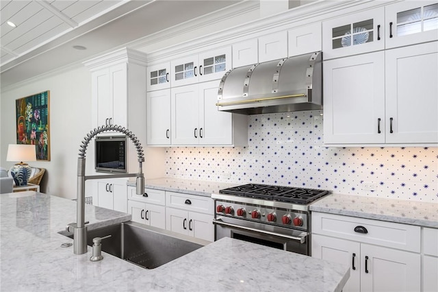 40 White Orchid Way, Vero Beach, FL 32963 - kitchen with extractor fan, high end range, a sink, tasteful backsplash, and white cabinetry
