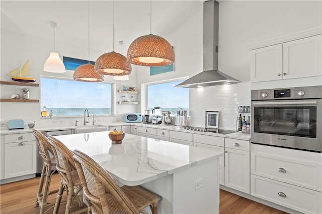 kitchen featuring ventilation hood, white cabinets, and appliances with stainless steel finishes