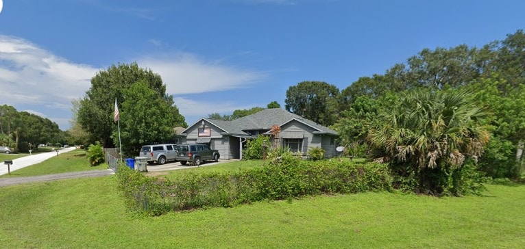8516 99th Ct, Vero Beach, FL 32967 - view of front of house with a front yard and driveway