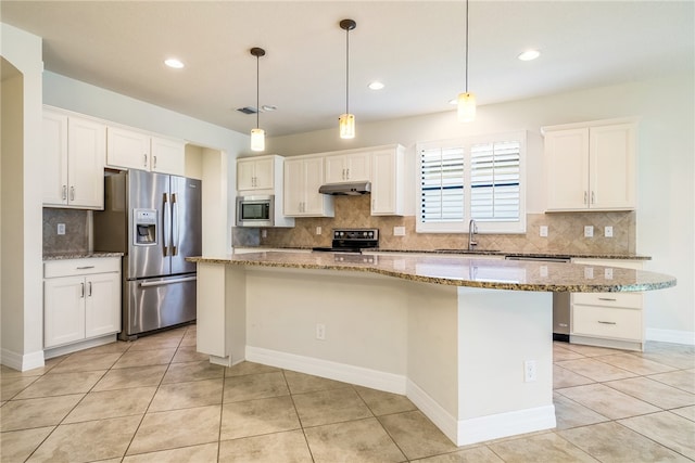 kitchen with appliances with stainless steel finishes, sink, decorative light fixtures, white cabinets, and a kitchen island