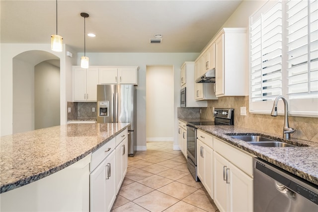 kitchen featuring white cabinetry, sink, light stone countertops, decorative backsplash, and appliances with stainless steel finishes