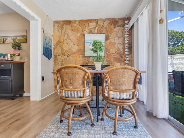 dining space featuring baseboards and wood finished floors