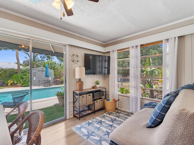 living area featuring crown molding, a textured ceiling, and wood finished floors