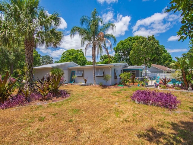 back of house with fence, stucco siding, and a yard