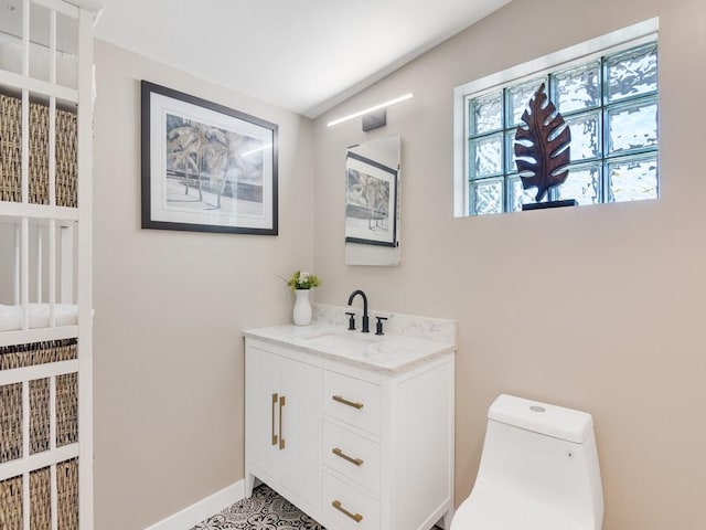 bathroom featuring vanity, baseboards, and toilet