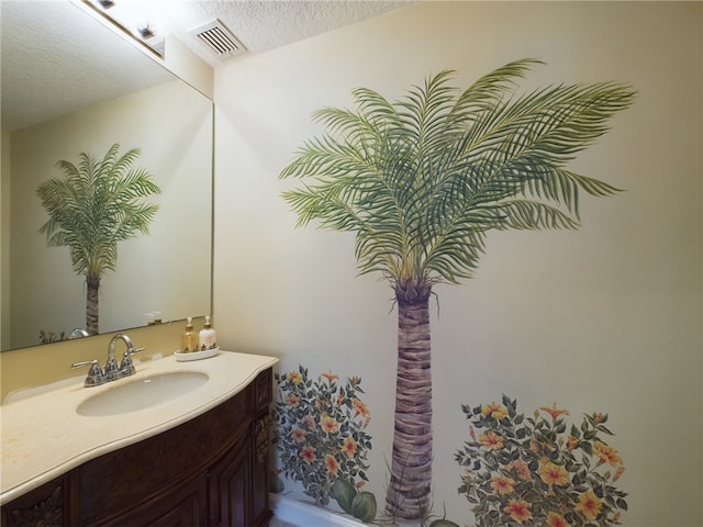 bathroom featuring visible vents, a textured ceiling, and vanity